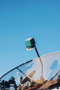 Modern satellite dish pointing skyward against a vivid blue sky in Rio Vermelho, Brazil.